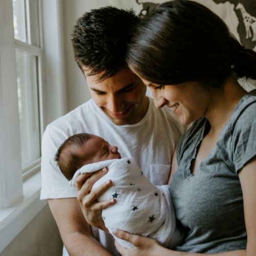 Parent tenant son nourrisson dans les bras – accompagnement parentalité Physio Care