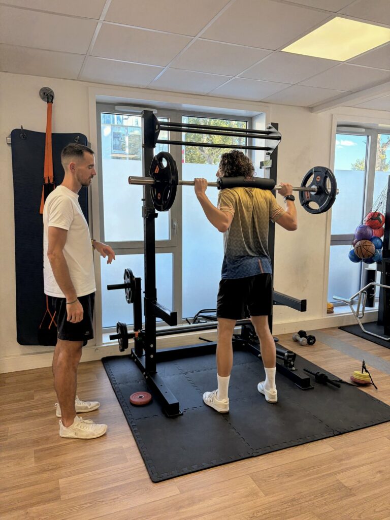 Kinésithérapeute encadrant un exercice de squat en renforcement musculaire